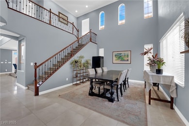 Dining area featuring a towering ceiling, baseboar