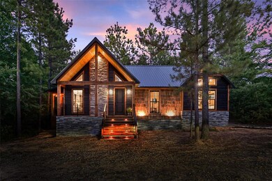 View of front of property with stone siding, covered porch, and a metal roof