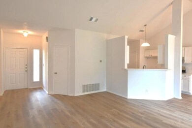 Entryway featuring wood finished floors, vaulted 