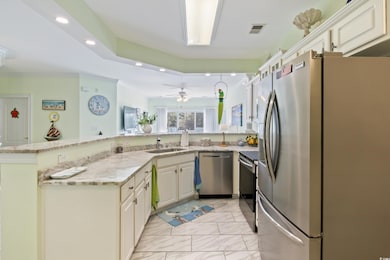Kitchen with a sink, stainless steel appliances, recessed lighting, and a peninsula