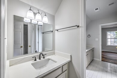 Bathroom featuring wood-type flooring, vanity, vaulted ceiling, and a chandelier