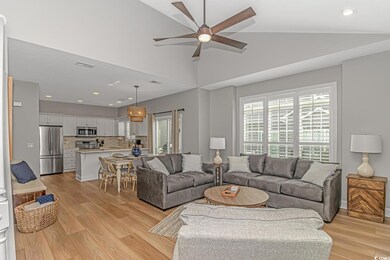 Living room featuring light hardwood / wood-style floors, high vaulted ceiling, and ceiling fan