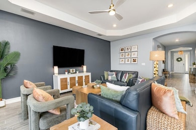 Living room with ceiling fan, a raised ceiling, an