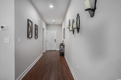 Hallway with wood finished floors, baseboards, and recessed lighting