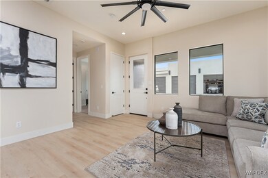 Living room with ceiling fan and light wood-type f