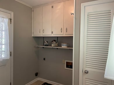 Washroom with hookup for an electric dryer, hookup for a washing machine, and cabinet space