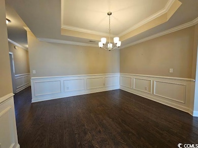 Unfurnished room with a chandelier, dark hardwood 