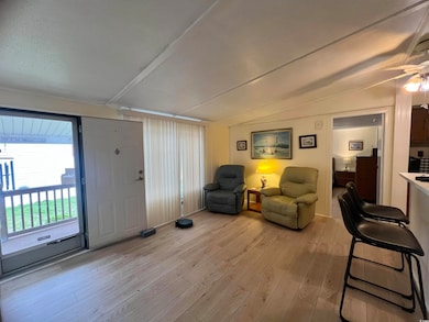 Sitting room with light wood finished floors and vaulted ceiling