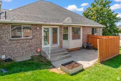 Rear Entrance to property featuring brick siding, patio and grow box, bay window