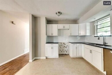Kitchen with sink, white cabinets, and light wood-type flooring