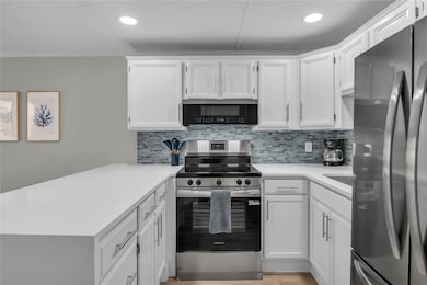 Kitchen features quartz countertops, glass tile backsplash and new stainless steel appliances.