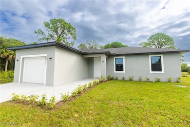 Ranch-style home with a garage, stucco siding, a front lawn, and concrete driveway