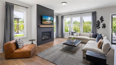 Living room with light wood-style flooring, a fireplace, recessed lighting, plenty of natural light. Photos are of the Tallulah Model Home and are not representative of actual home. Designer features may vary.