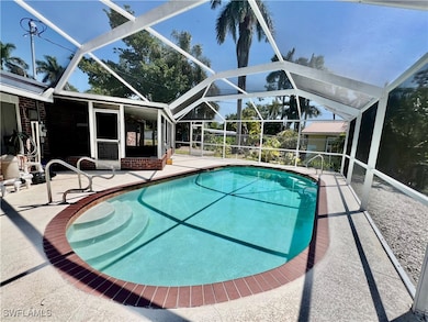 Outdoor pool featuring screen enclosure and a pati