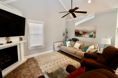 Tiled living area featuring baseboards, a fireplac