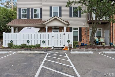 View of front of property featuring uncovered parking, a gate, a fenced front yard, and brick siding