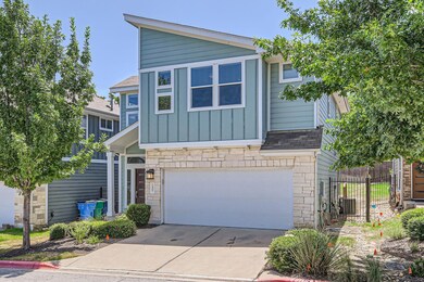 View of front facade featuring stone siding, a ga