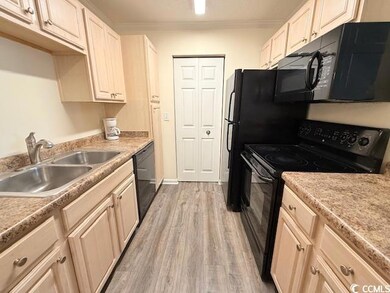 Kitchen with crown molding, light hardwood / wood-