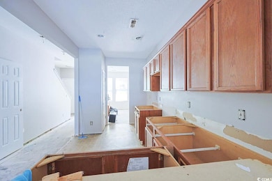 Kitchen with brown cabinets and a textured ceiling