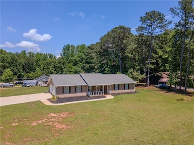 Ranch-style home with a porch, driveway, a front y