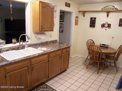 Eat In Kitchen is spacious w/ceramic tile flooring, new ceiling fan/light fixture, 3 other new ceiling lights, lots of cabinets/counter/drawer space, eat-in area for table and chairs, door access to Family Room, rear door to exterior home, newer counter tops and a viewing window into the Family Room.