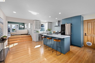 Kitchen with a kitchen bar, a kitchen island, glass insert cabinets, decorative backsplash, and appliances with stainless steel finishes