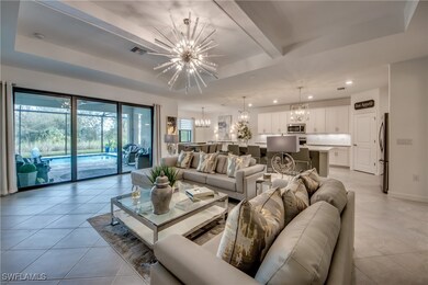 Living room with a raised ceiling, a chandelier, a