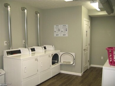 Laundry room with separate washer and dryer and dark wood-type flooring
