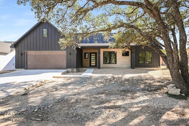 View of front of property featuring board and batten siding, driveway, and a shingled roof