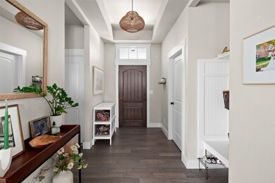 Foyer featuring a raised ceiling and dark wood finished floors