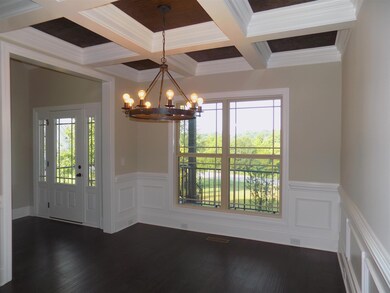 Formal dining with coiffured ceiling.