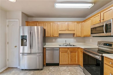 Kitchen featuring a sink, light countertops, and a