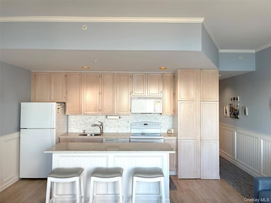 Kitchen featuring a white appliances, an island light wood finished floors