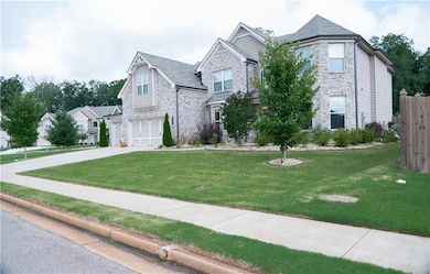 View of front facade with concrete driveway, an attached garage, and brick siding