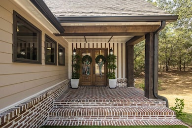 Entrance to property featuring a porch and a shingled roof
