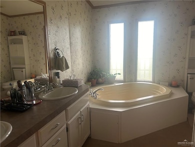 Sunlight, double sink vanity, a bathing tub, and toilet