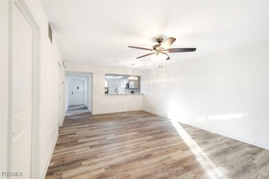 Unfurnished living room featuring light wood finished floors, ceiling fan, and a chandelier