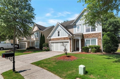 View of front of house with board and batten siding, stone siding, driveway, and a front lawn