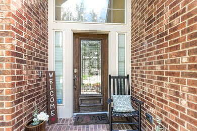 Inviting front yard with a covered porch. The entry features all-brick flooring and a wood front door, providing keyless entry. Very appealing!