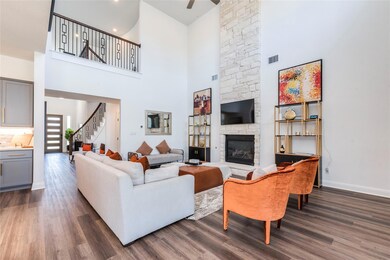 Living area with a high ceiling, stairs, dark woo