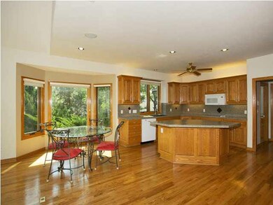 Kitchen has wood floor, center island and breakfas