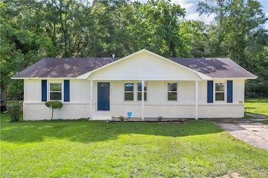 Ranch-style home featuring a front lawn, roof with shingles, and brick siding