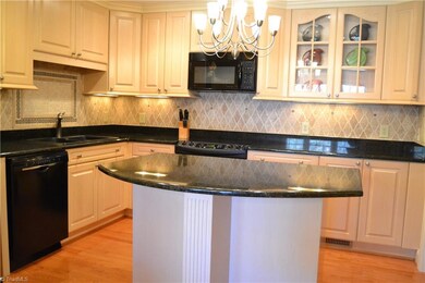 Abundant cabinets, granite counters, island allows stools, nice tumble tile backsplash, glass front cabinets to display your treasures.