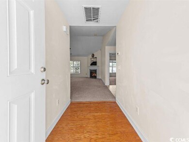Hallway featuring lofted ceiling and light wood-style flooring