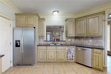 Kitchen with decorative backsplash, crown molding,