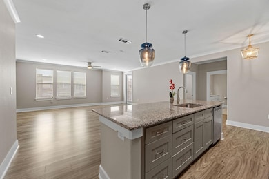 Kitchen featuring visible vents, a sink, light woo