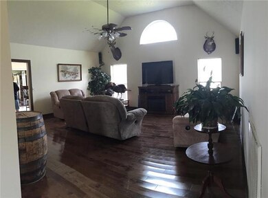 Spacious living room with vaulted ceiling, hardwood flooring and lots of natural light. 