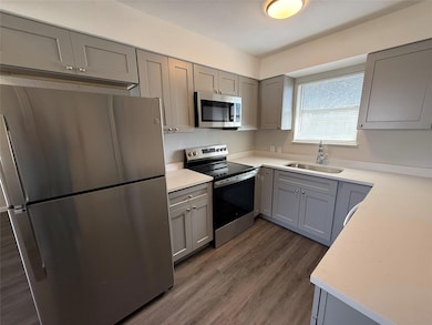 Kitchen with gray cabinetry, stainless steel appl