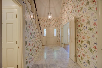 Soaring two story foyer with detailed moulding, st