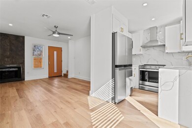 Kitchen featuring wall chimney range hood, applia